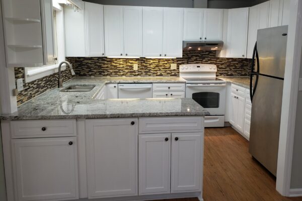 Prepare for showings by clearing any surface. This photos shows a kitchen with bare counters and all lights on. This is best staging you can give your kitchen counters.