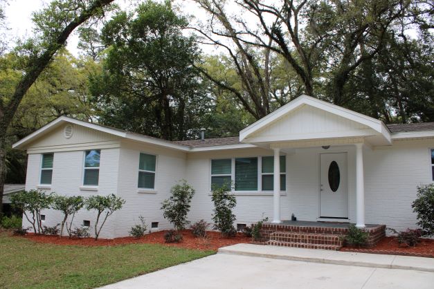 Older home on Sharon Road in Tallahassee is pictured. It is white brick with a covered front step and a new driveway.